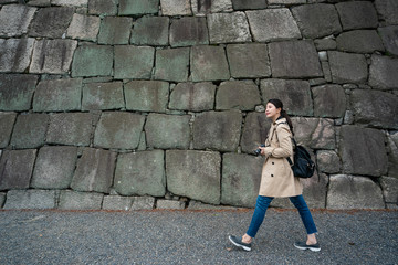 traveler walking by the stone wall