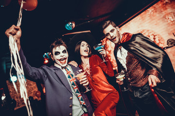 Young People Drinking Cocktails at Halloween Party