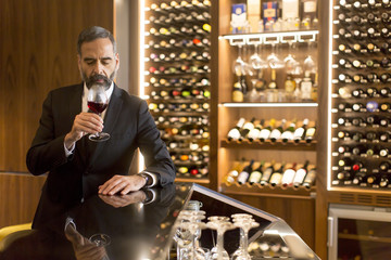 Senior handsome man drinking red wine