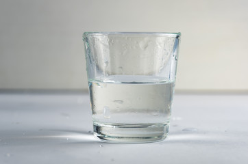 falling, flying or standing glass with a clear liquid intended for vodka and splash of liquid