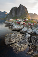 Fototapeta na wymiar Warm sulight hitting houses in the town of Moskenes during early morning hours. Lofoten, Norway.