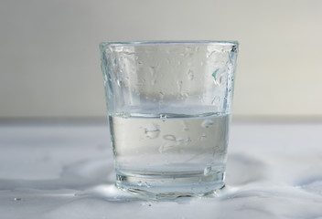 falling, flying or standing glass with a clear liquid intended for vodka and splash of liquid