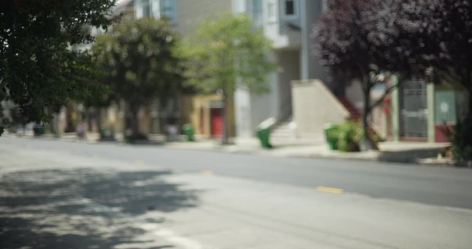 Street scene of empty neighborhood in San Francisco with trees blowing in wind