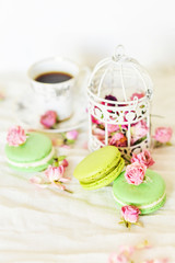 Obraz na płótnie Canvas Dessert: A Delicate Fresh Colorful French Macaroons In Pastel Colors With Flowers Roses On A Light Textile Background, Top View