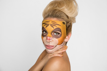 Beautiful woman with moisturizing leopard face mask. Mask with leopard, cat.