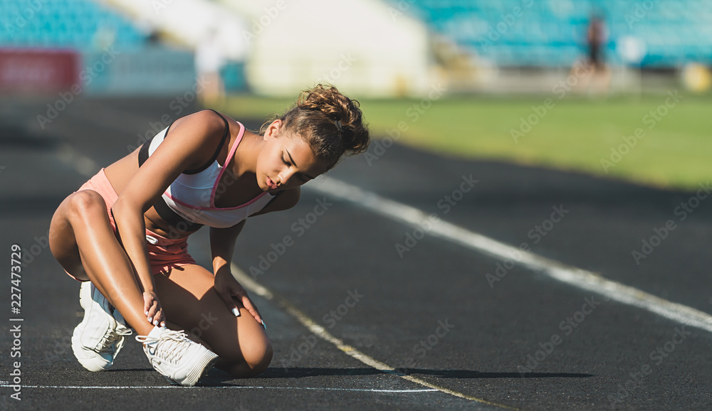 Wall mural sports injury painful scratches and open wounds on leg of runner girl that has fallen on running tra