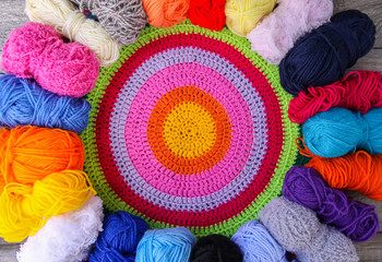 Skeins of bright woolen yarn in a wooden box on old wood background.