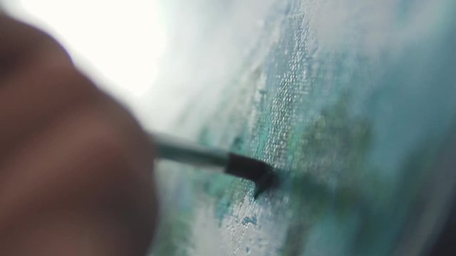 the painter makes a brush stroke on the picture. closeup paint brush