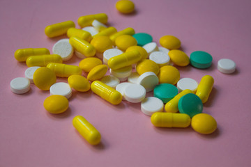 closed up colorful antibiotic capsules pills tablets isolated on pink background