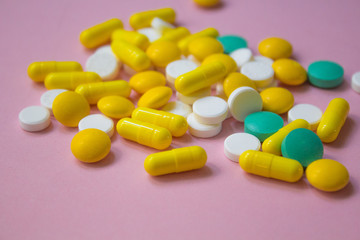 closed up colorful antibiotic capsules pills tablets isolated on pink background