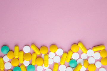 closed up colorful antibiotic capsules pills tablets isolated on pink background, copy space