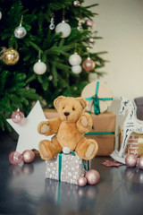gifts under the Christmas tree, toy bear and boxes, the concept of a cozy home new year