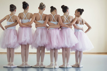 Group of ballerinas posing together with back to camera