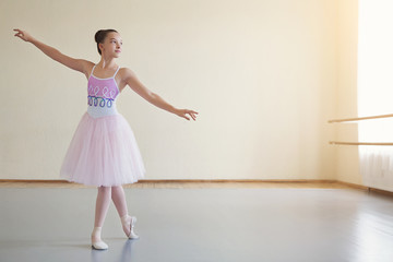 Little ballerina in ballet costume and pointe shoes