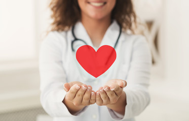 Doctor holding red heart in cupped hands