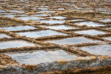 Salinas. Salt Pans or salters in Marsalforn Malta Gozo. rough sea filling them up.