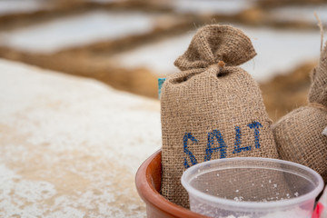 Gozo Salt bags harvested freash for turist to taste near salt pans or salinas. Horizontal. space for text. blurred background.