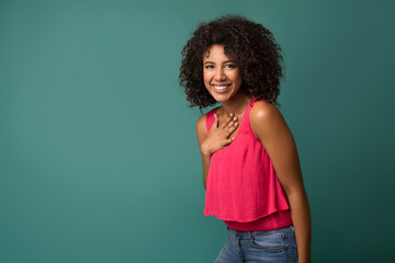 Cheerful african-american woman holding hand on chest