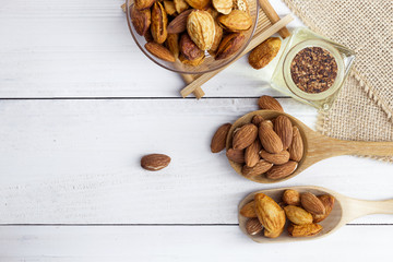 Almonds in a black bowl against dark rustic wooden background