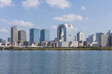 淀川右岸から見た対岸の梅田ビル群と青空
