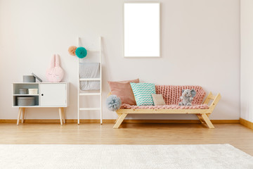 Bright kid room interior with wooden couch with powder pink coverlet, cushions and elephant, white...