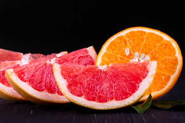orange and grapefruit juice On a wooden black background