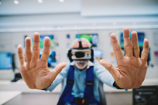 Virtual reality knocks at the door. Senior trying new virtual reality goggles.