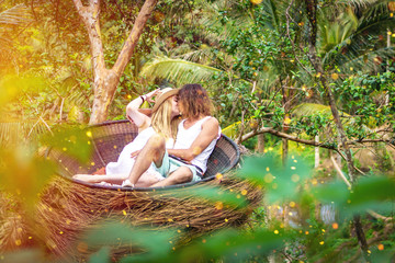 Traveler honeymoon couple in decorative nest the jungle of Bali island, Indonesia. Couple in the rainforest.