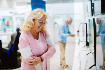 Beautiful senior woman portrait at tech store. Looking for a new