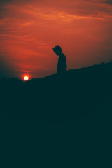 Fototapeta premium Boy looking at sunset