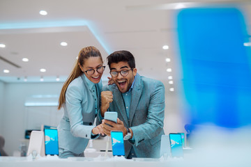 Couple at tech store looking for a new mobile phone.