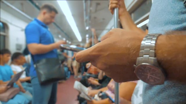Casual man reading from mobile phone smartphone screen while looks the navigator traveling on metro in the subway. slow motion video lifestyle. Wireless internet on public transport concept. man in