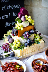 A British cheese wedding cake with cheddar, Red Leciester and hard goats cheese decorated with figs, grapes and herbs.