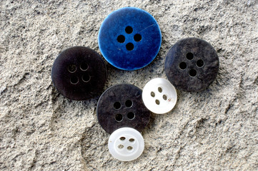 old used sewing button on a cement background