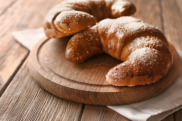 Tasty fresh crescent rolls on wooden board