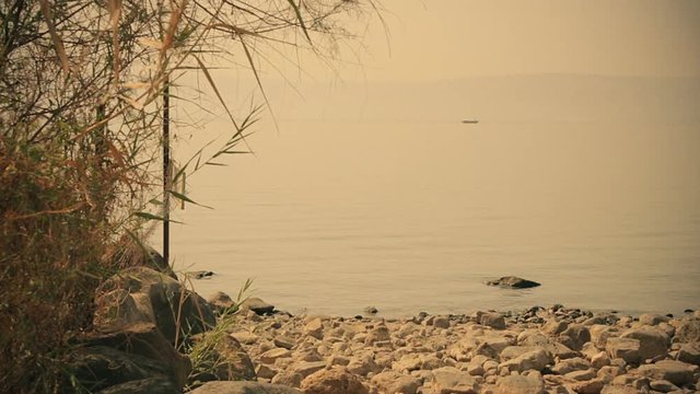 Sea of Galilee in the early morning, ripples on the water and boat. Israel, cca. 2015