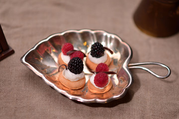 cookies with mousse and berries on a silver plate