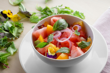 Bowl with delicious watermelon salad on plate