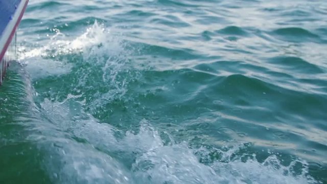 Boat on water causing waves and ripples. Slow motion footage.