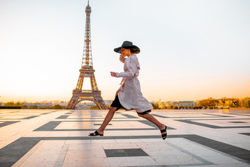 Woman jumping on the famous square with great view on the Eiffel tower early in the morning in Paris