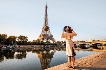 Young woman tourist enjoying landscape view on the Eiffel tower with beautiful reflection on the...