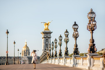 View on the famous Alexandre bridge with beautiful woman walking during the morning view in Paris