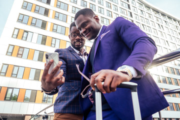 two handsome and young african american men making selfie portrait on smartphone in the airport
