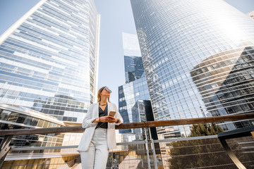 Portrait of a young business woman outdoors with high skyscrapers on the background