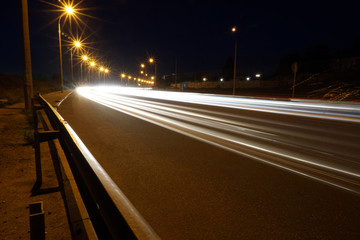 Empty asphalt road during the night with light trails background. Night urban scene with car light...