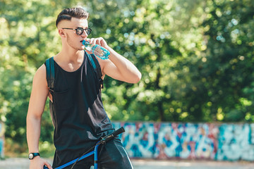young teenage boy having a rest on the bmx bike on the park