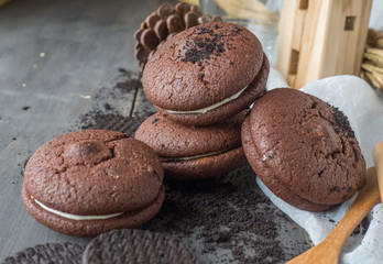 Chocolate cookies and brownie biscuit on black wood table.