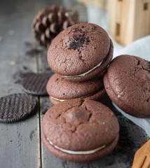 Chocolate cookies and brownie biscuit on black wood table.