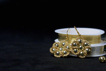 Bead jewelery. DIY jewelry. Necessary accessories. Beads and ready-made earrings. Tools and fixtures. On a black background.