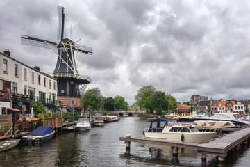 Fototapeta na wymiar The eight-sided smock mill De Adriaan on the river De Spaarne in Haarlem